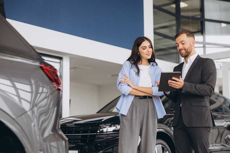 A buyer reviews a certified pre-owned vehicle inspection report beside a parked used car.